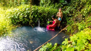 Erkek ve kız kardeşler doğal bir banyoda yıkanıyor.