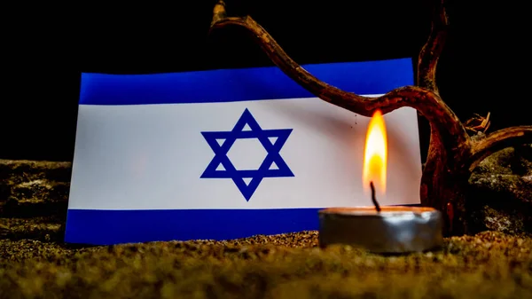 stock image Israeli flag and burning candles in front of it, Holocaust memory day