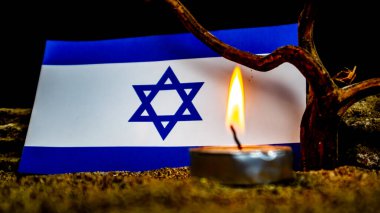 İsrail bayrağı ve önünde yanan mumlar. Soykırım anıları günü.