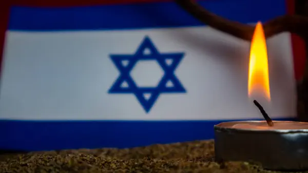 stock image Israeli flag and burning candles in front of it, Holocaust memory day