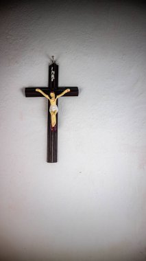 Beyaz bir duvara asılmış bir haç.