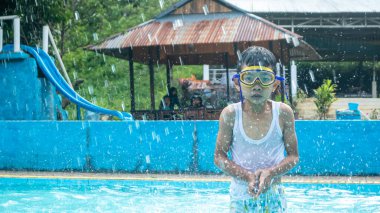 Bir çocuk gözlük takarak yüzüyor.