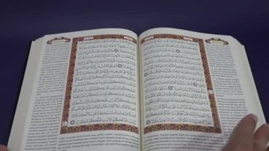Banda Aceh, Endonezya - 10 Aralık 2024: Kuran 'ın kutsal sayfalarını karıştıran kişi. Yakın plan..