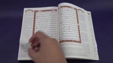 Banda Aceh, Endonezya - 10 Aralık 2024: Kuran 'ın kutsal sayfalarını karıştıran kişi. Yakın plan..