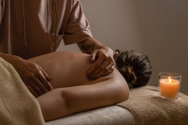 Masaj salonundaki siyah ışıklandırmalı bir kıza sırt masajı yapan kadınların yakın çekimleri. Sağlık, vücut bakımı, kaplıca kavramı