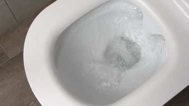 Flush toilet. Water flushes toilet. Flow of water is clearly visible. water in ceramic toilet. Retarded motion. Flow of water comes from mouth itself or beginning.
