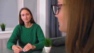 Kadın psikolog konuşur ve kıza yardım eder. Önemli çalışmaları tablete kaydediyor, arkadan ya da arkadan görüyor. Psikoloji, akıl sağlığı kavramı. Psikoterapistle görüşme.