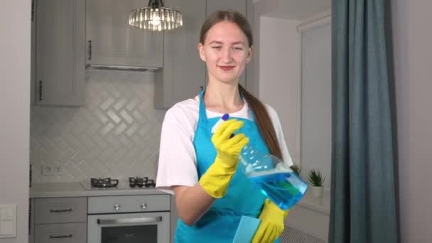 Jonge Vrouw Uniform Schort Spuit Wasmiddel Lucht Glimlacht Schoonmaak Appartement — Stockvideo