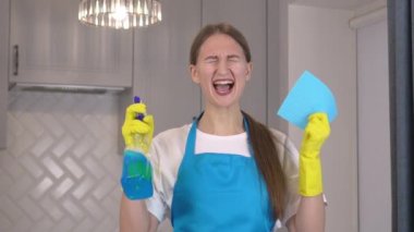 Üniformalı ve önlüklü kadın elinde temizlik malzemesi ve paçavra tutuyor. Tatmin olmamış, rutin çığlıklar atıyor ve çok depresif. Temizlik işinden nefret ediyor. Temizlik. Kadın işi. .
