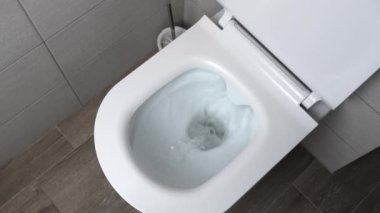 Flush toilet. Water flushes toilet. Flow of water is clearly visible. water in ceramic toilet. Retarded motion. Flow of water comes from mouth itself or beginning.
