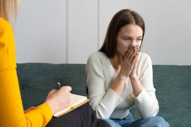 Genç üzgün kadın bir psikoterapist randevusunda ellerini yüzüne dayayıp kanepede oturuyor. Müvekkili olan bir psikolog. Fotoğraflar psikologdan.