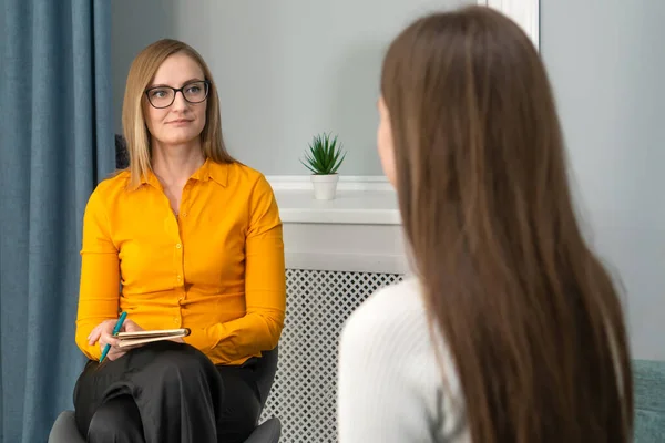 Business woman with glasses is interviewing a young woman for a job. Concept of employment, business, consultations