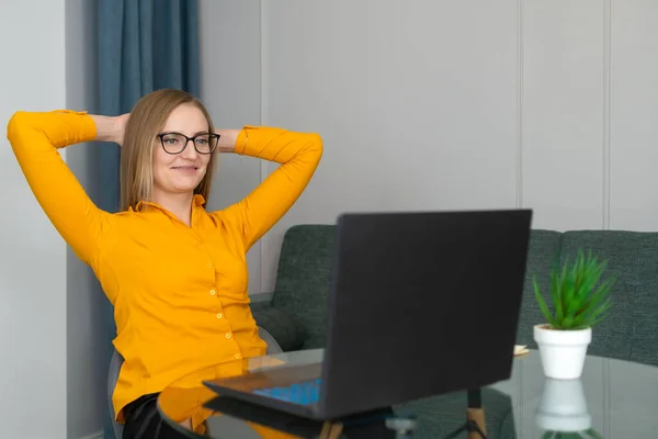 Uśmiechnięta Młoda Bizneswoman Okularach Zakończyła Pracę Komputerową Siedząc Przy Biurku — Zdjęcie stockowe