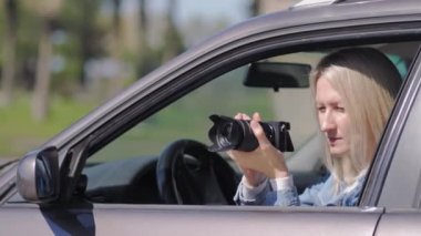 Paparazzi kadın ya da kız arabasında oturup ünlü birinin fotoğraflarını çekiyor. Arabada kamera olan bir casus. Özel dedektif ya da paparazzi gazeteci arabada oturuyor, kamerayla fotoğraf çekiyor..