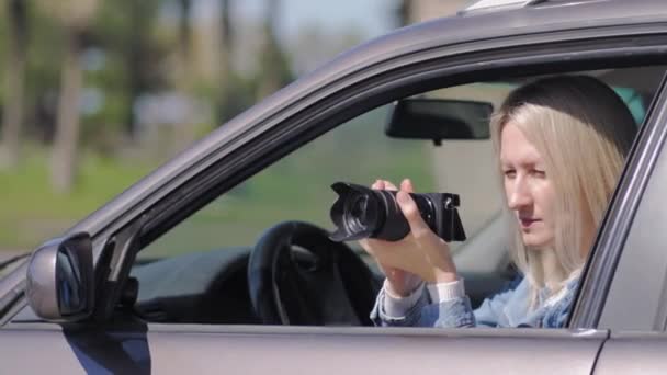 狗仔队的妇女或女孩坐在她的车里 为名人拍照 车里有摄像头的间谍私家侦探或狗仔队记者坐在车内 用相机拍照 — 图库视频影像
