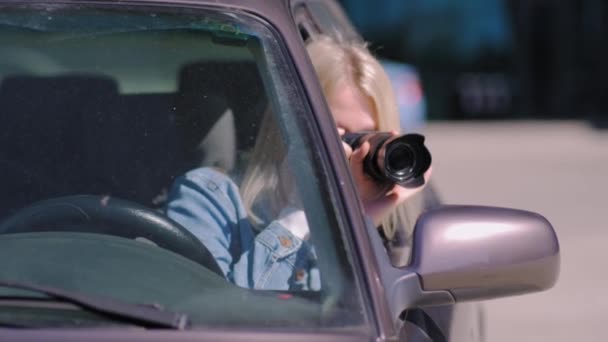 拿着相机的女人坐在车里 用专业相机 私家侦探或狗仔队间谍拍照 记者寻求联合 并跟随名人 — 图库视频影像