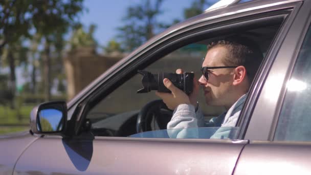 Człowiek Kamerą Siedzi Samochodzie Robi Zdjęcia Profesjonalną Kamerą Prywatnym Detektywem — Wideo stockowe