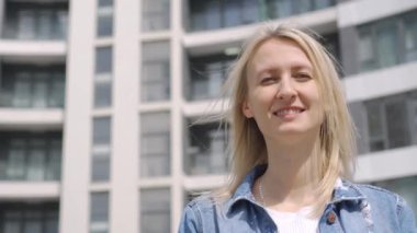 Kadın kiracının ya da ev sahibinin yakın plan fotoğrafları, yeni inşa edilen bir binanın, aile ocağı ve konut sembolünün arka planında anahtarlık ve anahtarlık gösteriyor. Emlak satın alımı.