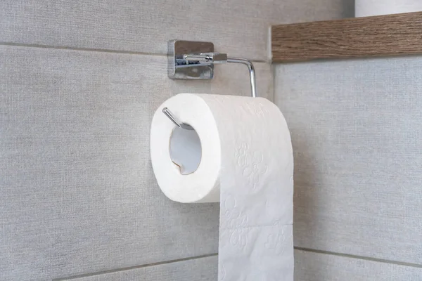 Rolka Białego Papieru Toaletowego Błyszczącym Uchwycie Zawieszonym Jasnoszarej Ścianie Dachówki — Zdjęcie stockowe