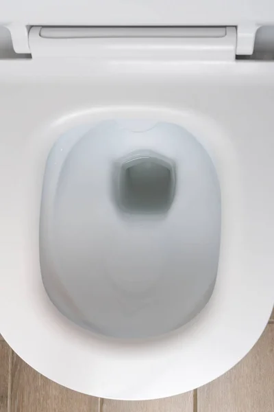 现代厕所里新的白色陶瓷马桶的顶视图 垂直照片 — 图库照片