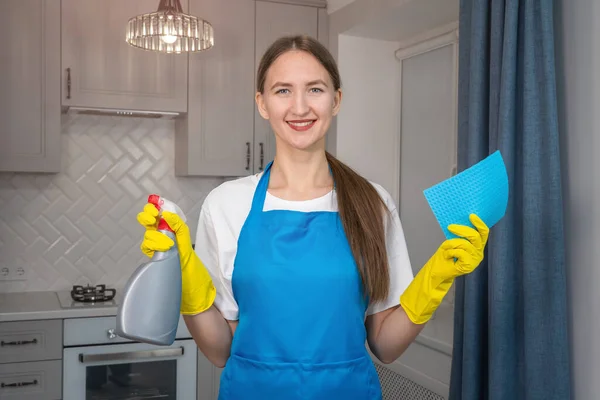 Χαμογελαστή Νεαρή Γυναίκα Μπλε Ποδιά Κίτρινα Λαστιχένια Γάντια Κρατά Ένα — Φωτογραφία Αρχείου