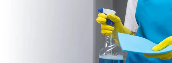 一名身穿制服和黄色橡胶手套 手持洗涤剂和微纤维布的妇女的特写镜头 清洁公寓 展示喷雾和清洁用品 清洁公司 — 图库照片
