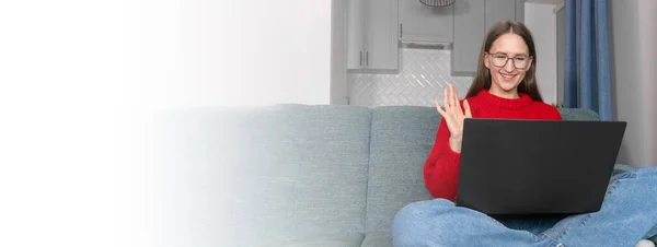 안경을 미소짓는 스웨터를 컴퓨터 흔든다 소녀는 비디오 온라인 대화에서 인사를 — 스톡 사진