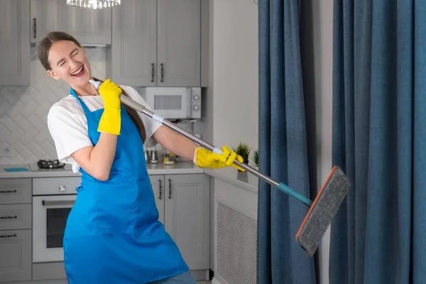 Szczęśliwa Młoda Profesjonalistka Firmy Sprzątającej Sprząta Dom Śpiewa Mopa Jak — Zdjęcie stockowe