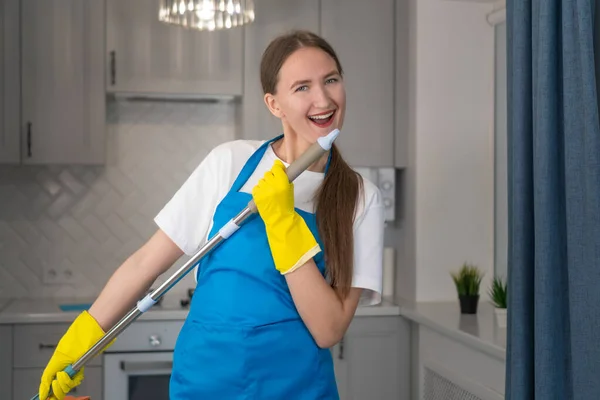 Szczęśliwa Młoda Profesjonalistka Firmy Sprzątającej Sprząta Dom Śpiewa Mopa Jak — Zdjęcie stockowe