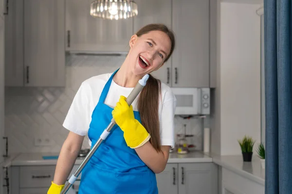 Beyaz Tişörtlü Önlüklü Dans Eden Evde Mutfağı Temizlerken Paspasla Şarkı — Stok fotoğraf