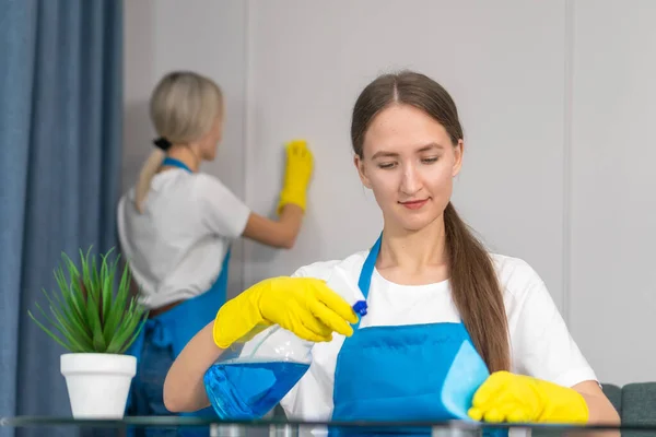 장비로 청소하는 직원들 청소하고 위생을 돌보는 군복을 여자가 식탁을 세제인 — 스톡 사진
