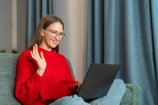 Young Smiling Woman Glasses Red Sweater Waves Her Hand While — Stock Photo, Image