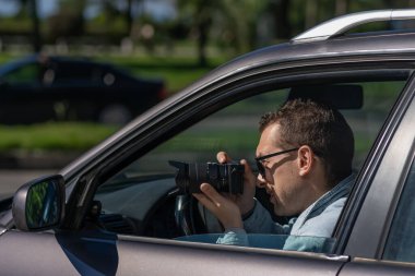 Gizli fotoğrafçılık. Paparazzi Concep Fotoğrafçısı profesyonel kamerasını kullanıyor. Araba vitrinindeki özel dedektif. Mobil muhabir. İş yerinde foto muhabiri. Dedektif ya da dedektif..