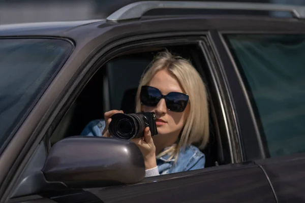 Paparazzi kadın ya da kız arabasında oturup ünlü birinin fotoğraflarını çekiyor. Arabada kamera olan bir casus. Özel dedektif ya da paparazzi gazeteci arabada oturuyor, kamerayla fotoğraf çekiyor..