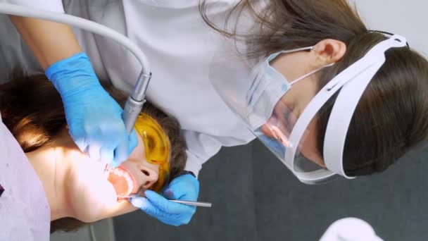 Οδοντίατρος Γυναίκα Αντιμετωπίζει Δόντια Της Νεαρής Γυναίκας Ασθενή Στην Κλινική — Αρχείο Βίντεο