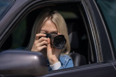 Paparazzi kadın ya da kız arabasında oturup ünlü birinin fotoğraflarını çekiyor. Arabada kamera olan bir casus. Özel dedektif ya da paparazzi gazeteci arabada oturuyor, kamerayla fotoğraf çekiyor..