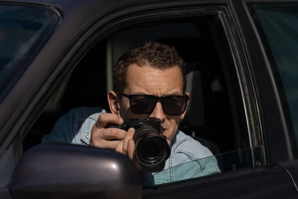 Kameralı güneş gözlüklü bir adam arabanın içinde oturur ve profesyonel kamerayla, özel dedektifle ya da paparazzi casusuyla fotoğraf çeker. Gazeteci sansasyon arıyor ve ünlüleri takip ediyor.