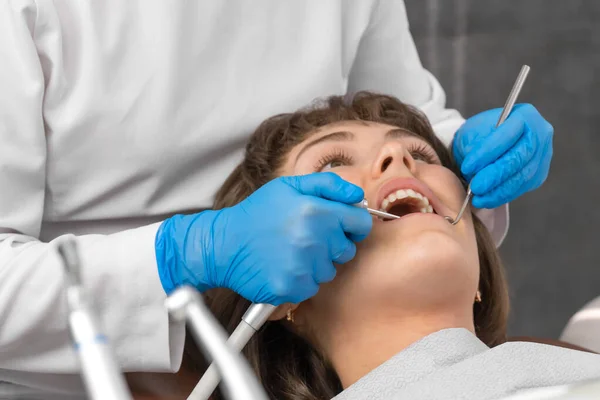 Dentista Con Guantes Azules Protectores Examina Los Dientes Una Mujer —  Fotos de Stock