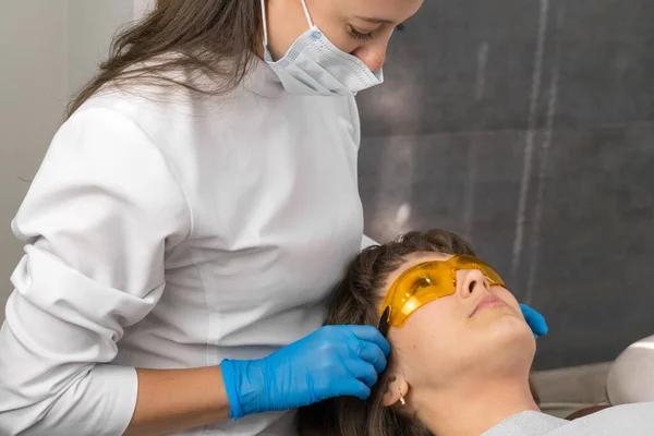 Dentysta Zakłada Pomarańczowe Okulary Ochronne Dla Pacjenta Krześle Dentystycznym — Zdjęcie stockowe