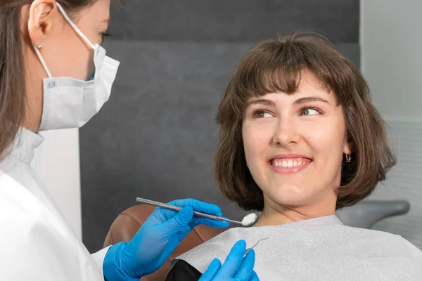 Mujer Sonriente Joven Está Sentada Una Silla Dental Mirando Dentista —  Fotos de Stock