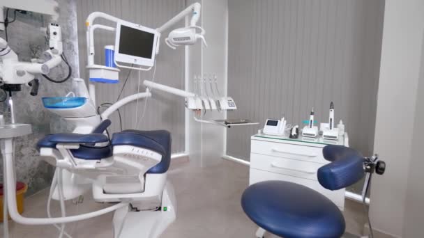 近代的な椅子とプロの機器と歯科医のオフィス オフィス周辺のカメラの動き ディスプレイやモニター 楽器や光と現代的なインテリア 顕微鏡及び椅子 — ストック動画