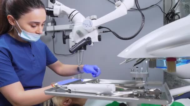 Dentystka Stosująca Mikroskop Stomatologiczny Gabinecie Stomatologicznym Poddawane Leczeniu Przez Doświadczonego — Wideo stockowe