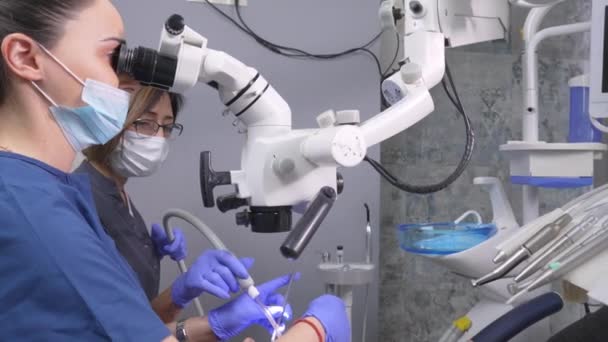 Дві Жінки Стоматолог Працюють Мікроскопом Зубів Доктор Його Асистент Стоматологічній — стокове відео
