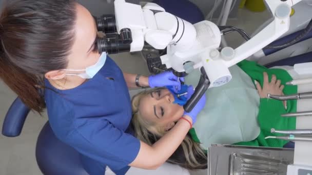 치과용 치과용 현미경으로 진료소를 치료하는 현미경을 사용하여 경험많은 의사의 치료를 — 비디오