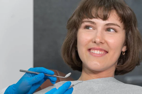 Mujer Sonriente Joven Está Sentada Una Silla Dental Mirando Dentista —  Fotos de Stock