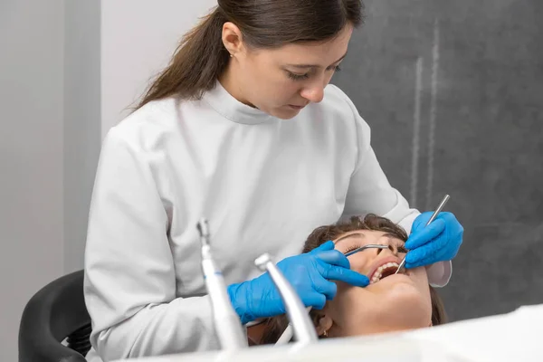 Dentista Con Guantes Azules Protectores Examina Los Dientes Una Mujer —  Fotos de Stock