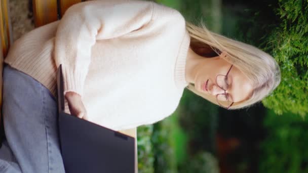 オンラインビジネスウーマン 若い女性はノートパソコンを通して市内のベンチに座ってテキストを入力し 晴れた日に働いています 教育の概念 フリーランサー 試験準備のための学生のラップトップコンピュータ 眼鏡で — ストック動画