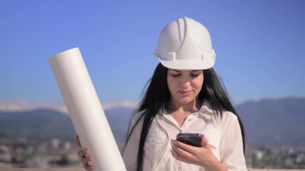 Kobieta Architekt Placu Budowy Kasku Posiada Telefon Komórkowy Składany Plan — Wideo stockowe