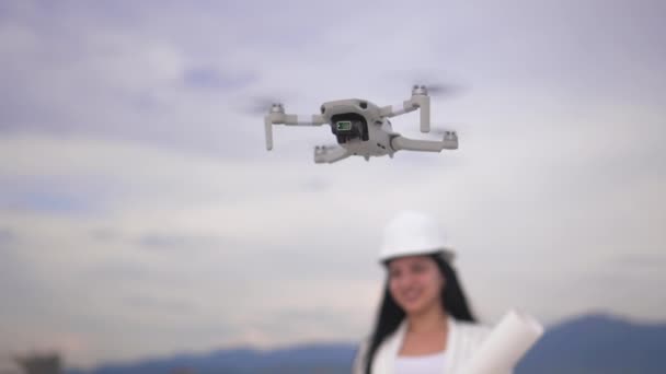 Concentre Drone Voando Pairando Contra Pano Fundo Defocus Mulher Capacete — Vídeo de Stock