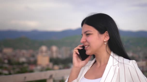 여자는 도시와 지붕의 곳에서 도시와 배경으로 핸드폰으로 이야기를 현장에서 일하는 — 비디오
